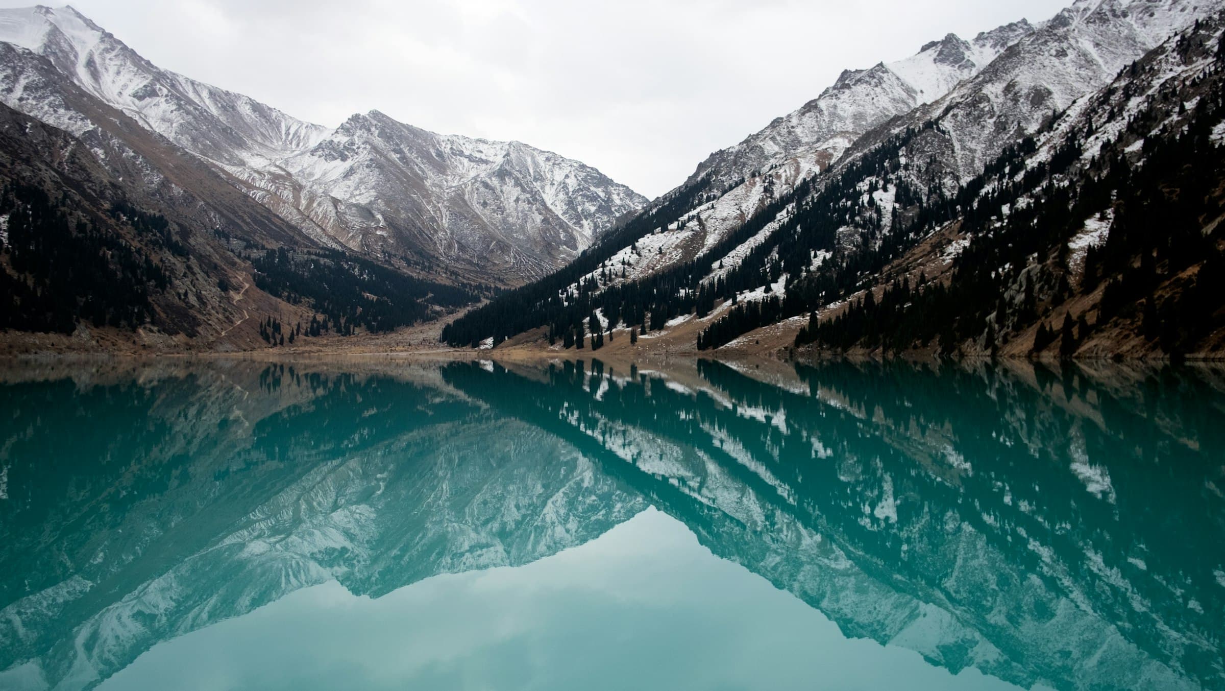 Snow-capped peaks reflected in the turquoise water of Big Almaty Lake