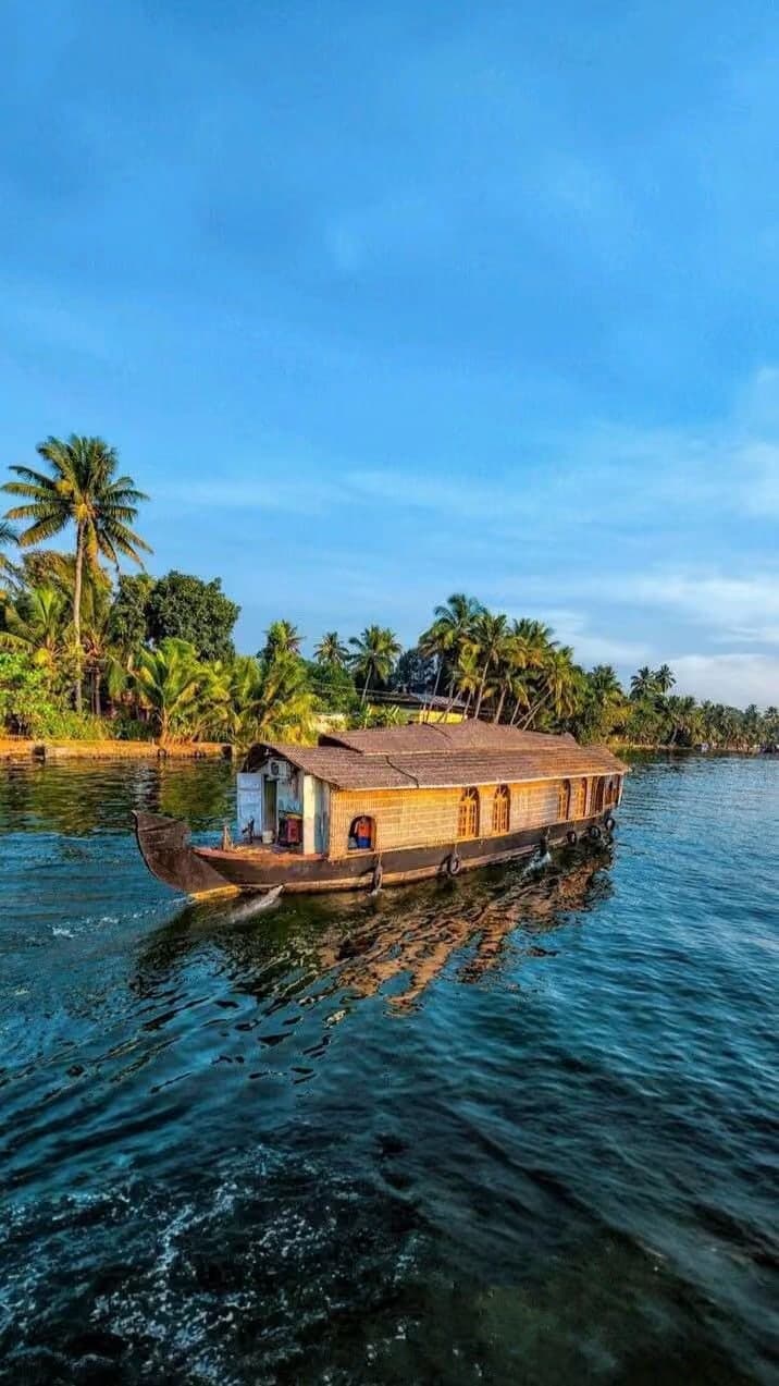 A traditional houseboat cruising the palm-lined Kerala backwaters