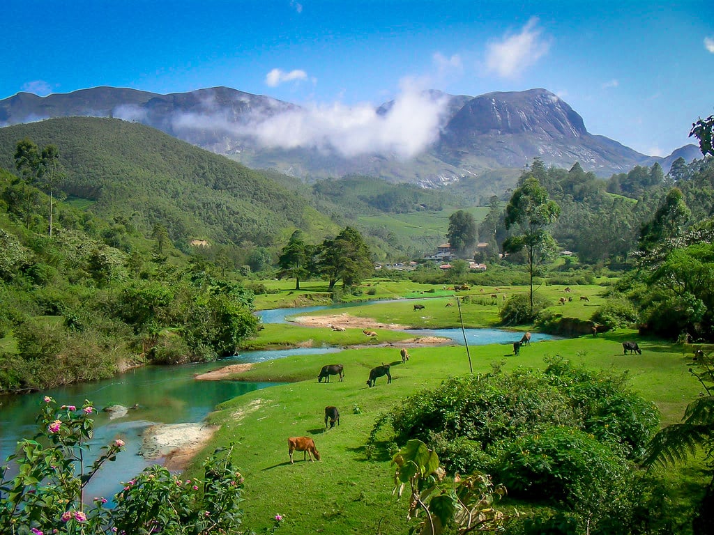 A river winding through green meadows beneath misty mountains