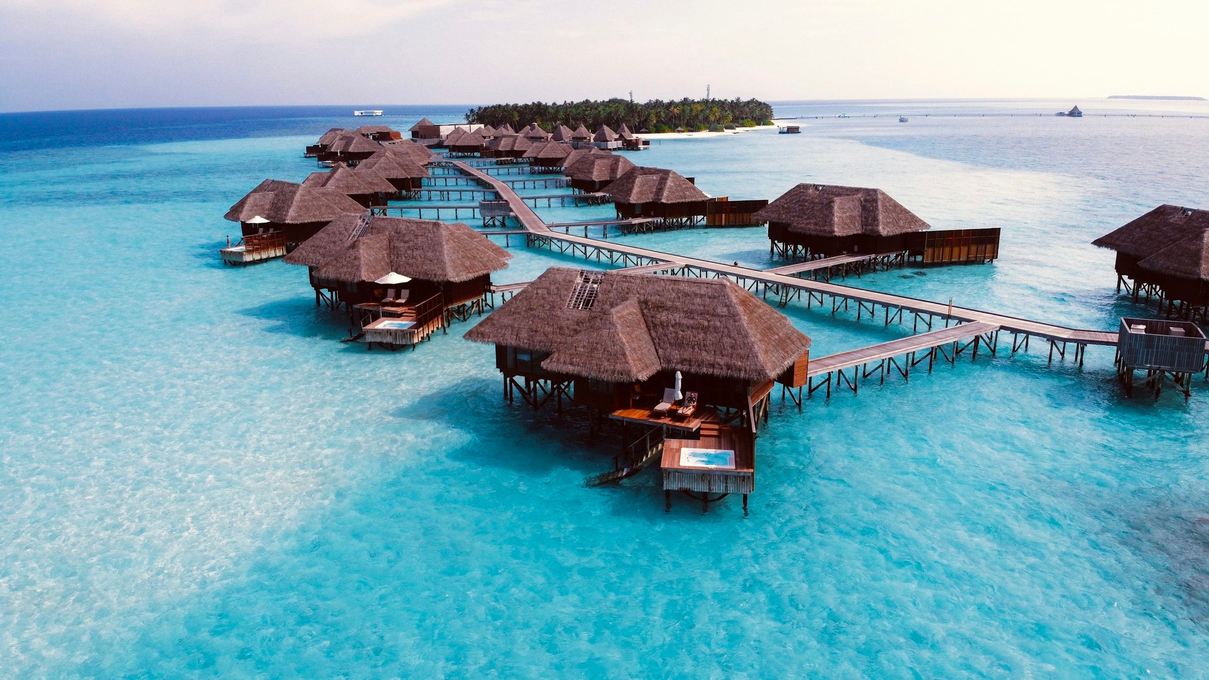Thatched water villas on stilts above a turquoise Maldives lagoon
